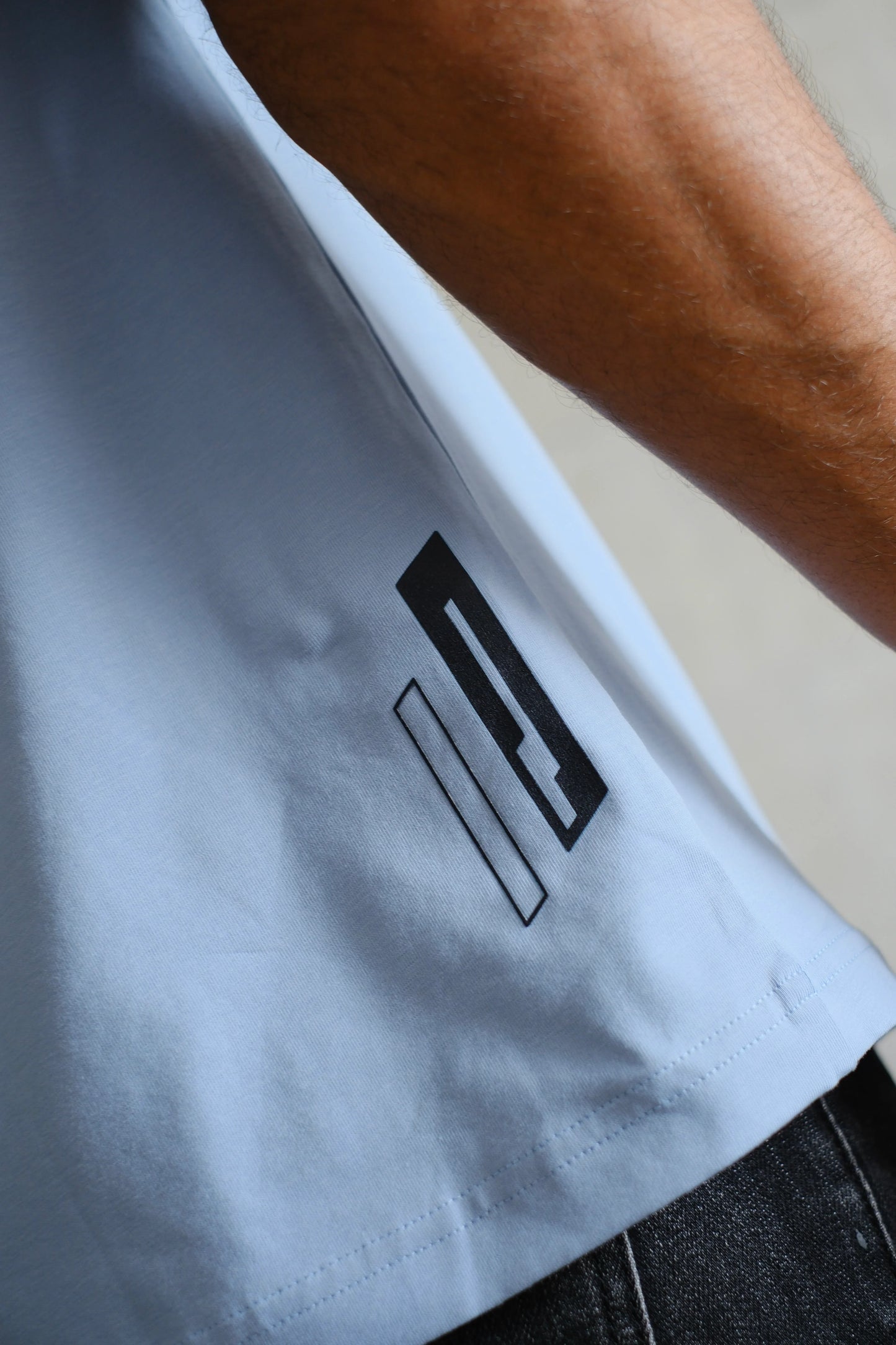 Camiseta azul claro con estampado geométrico negro en la parte inferior lateral
