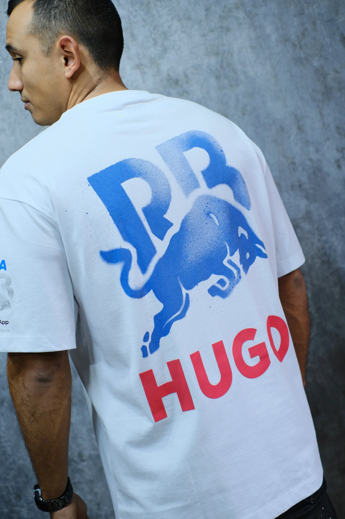 Camiseta blanca de hombre con estampado azul de toro y letras HUGO en rojo, estilo urbano
