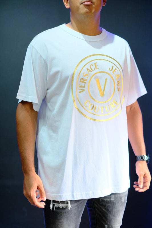 Camiseta blanca con logo dorado, estilo casual, jeans rotos, moda urbana masculina