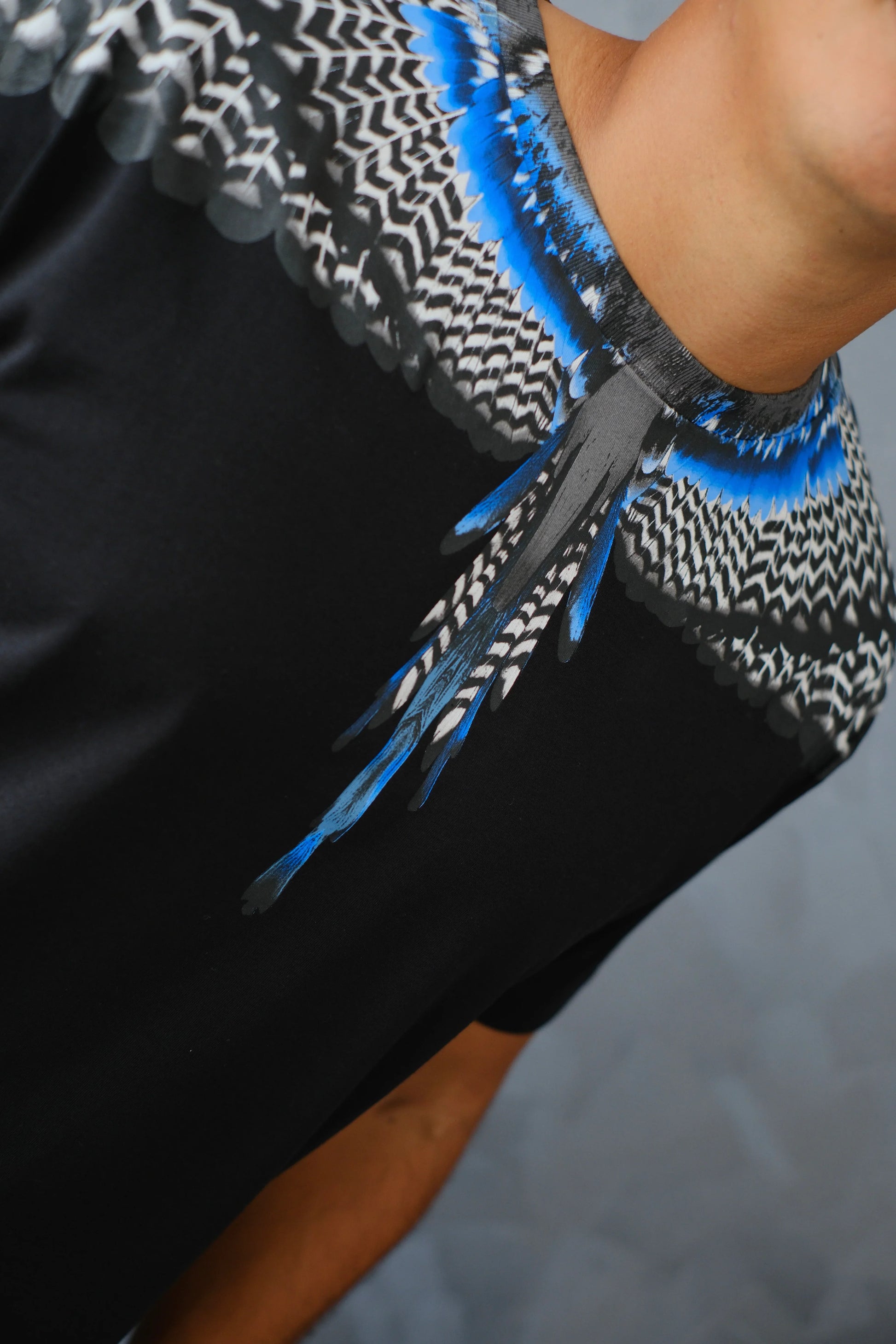 Camiseta negra con estampado de plumas azules y grises en el cuello para hombre