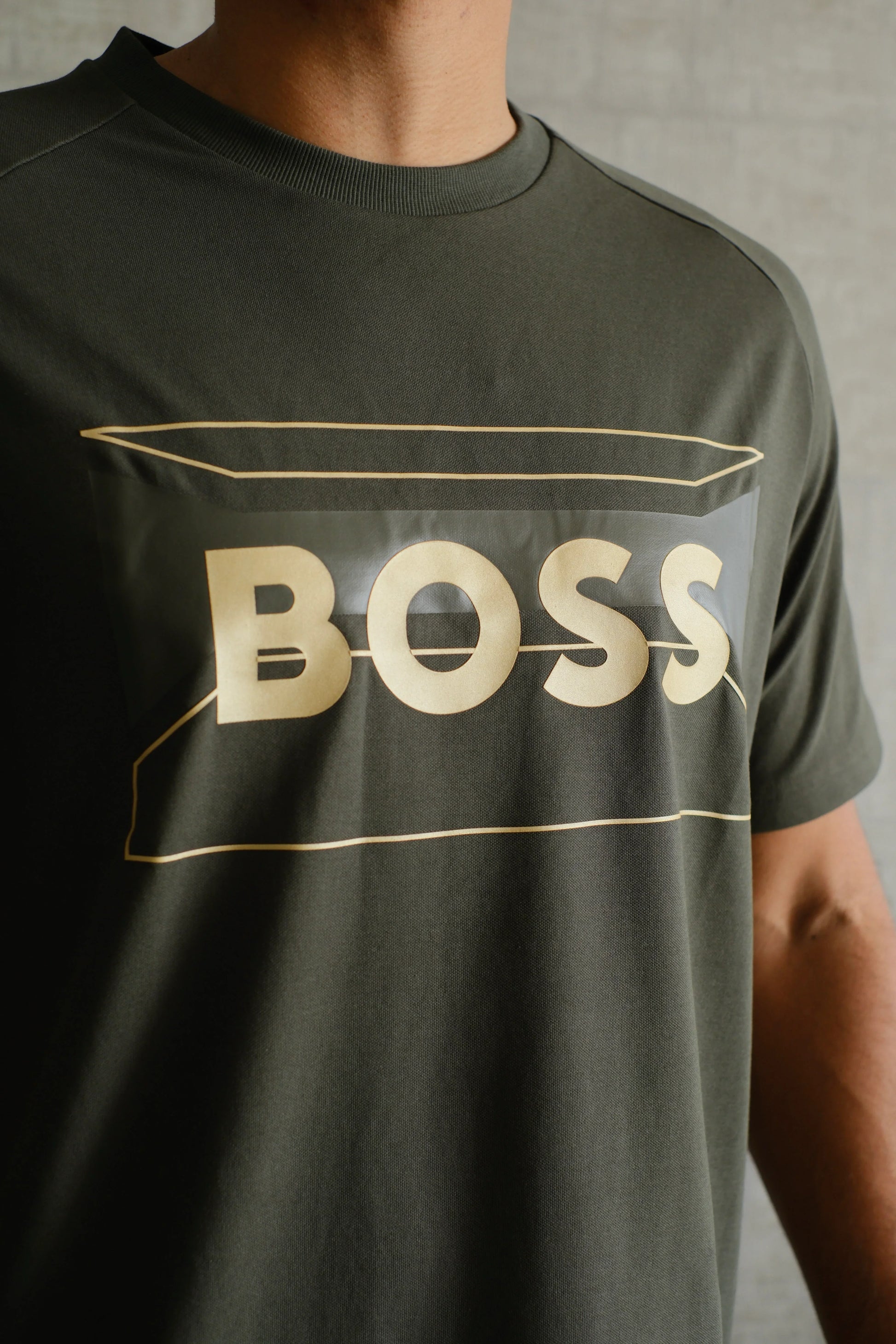 Camiseta verde con letras doradas BOSS en el pecho, ropa casual para hombre.