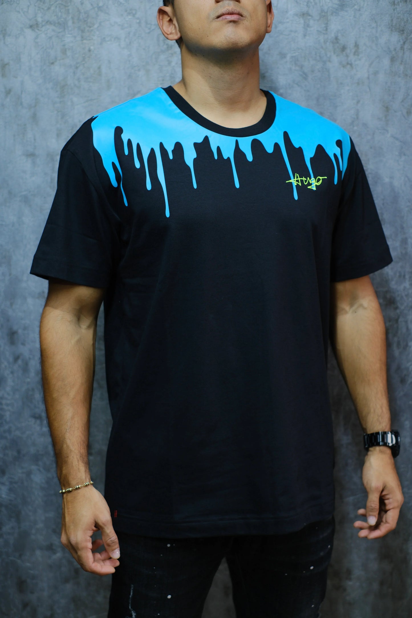 Camiseta negra de hombre con diseño azul tipo pintura líquida y logo gráfico, estilo urbano.