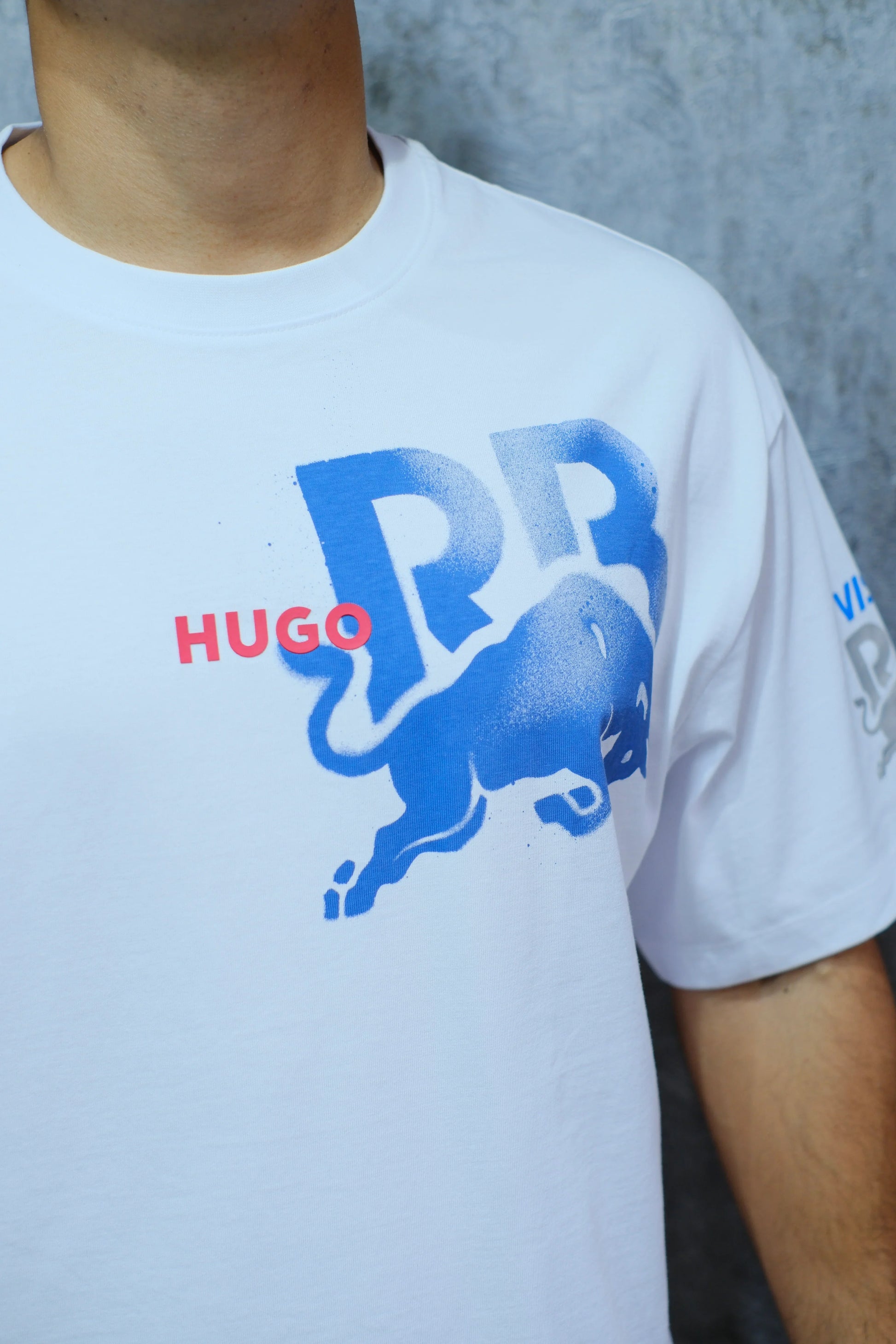Camiseta blanca con estampado azul de toro y letras RR, detalle en rojo HUGO, estilo urbano.